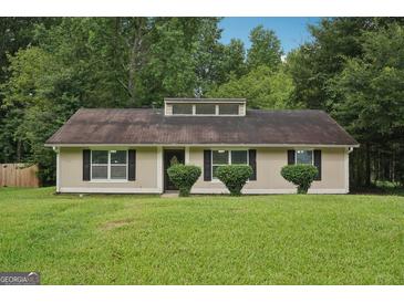 Charming single-story home with a well-maintained lawn and mature trees in a tranquil suburban setting at 7335 Connell Rd, Fairburn, GA 30213