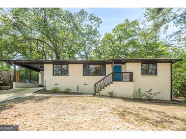 Charming single-story home featuring a blue front door, painted brick, a driveway and black trim at 3833 Bakers Ferry Sw Rd, Atlanta, GA 30331