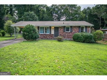 Charming one-story brick home featuring a covered front entrance and a well-manicured lawn at 6233 Castlewood Dr, Morrow, GA 30260