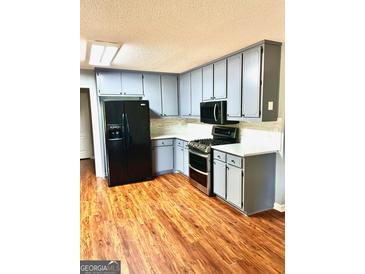 Stylish kitchen features stainless steel appliances, gray cabinetry and a beautiful stone backsplash at 398 Mckenzie Dr, Stockbridge, GA 30281