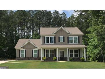Charming two-story home featuring a welcoming front porch and a beautifully landscaped lawn with a basketball hoop at 85 Crabapple Ridge Dr, Oxford, GA 30054