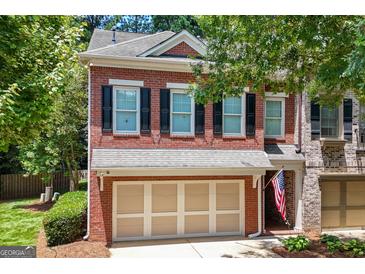 Charming two-story brick townhome with a two-car garage and beautifully landscaped front yard at 48 Star Spangled Ln, Peachtree City, GA 30269