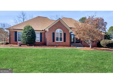 Charming single-story brick home with a well-manicured lawn and mature landscaping at 200 Magnolia Ct, Mcdonough, GA 30252