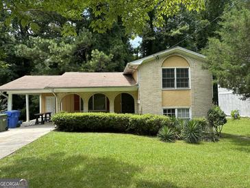Charming home with a brick facade, arched entryways, and a well-maintained lawn surrounded by mature trees at 273 Fennel Sw Way, Atlanta, GA 30331