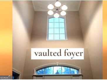 Bright foyer featuring a high vaulted ceiling, transom windows, and decorative lighting fixture at 30 Cynthia Ct, Fayetteville, GA 30215