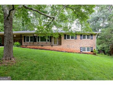 Charming brick home featuring a well-manicured lawn and a cozy front porch at 4852 Pine Shadows, Stone Mountain, GA 30088