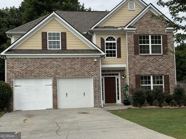Beautiful two-story home featuring a two-car garage, brick accents, and manicured landscaping at 4199 Elderberry Nw Dr, Acworth, GA 30101