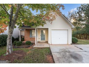 Inviting single-story home featuring a garage, landscaped front yard, and a charming entrance at 167 London Dr, Mcdonough, GA 30253