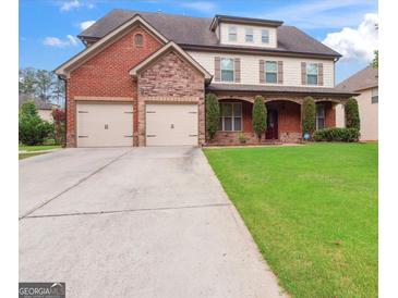 Two-story home with a brick and stone exterior, well-manicured lawn, and a two-car garage at 416 Fairway Dr, Acworth, GA 30101