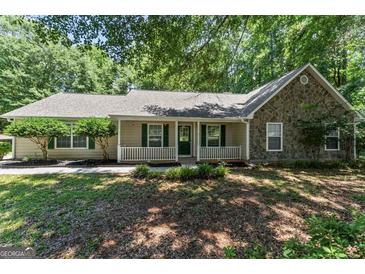 Charming single-story home featuring a stone facade, inviting front porch and nicely landscaped front yard at 380 Peach Drive, Mcdonough, GA 30253