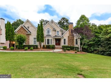 Stately brick home featuring manicured lawn, mature trees and decorative stone accents at 1360 Mount Mckinley Dr, Grayson, GA 30017