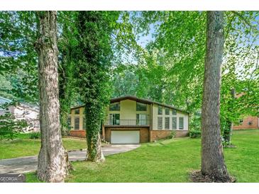 Two-story home featuring lush landscaping, a brick base, and a two-car garage at 6290 Shallowford Way, Douglasville, GA 30135