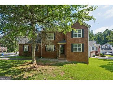 Traditional two-story brick home with a well-manicured front yard, under a large tree at 2326 Sand Dollar Sw Ct, Atlanta, GA 30331