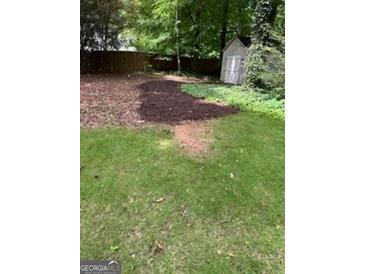 A backyard with an old shed, wood fence, and grassy area at 4887 Winterview Ln, Douglasville, GA 30135