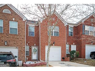 Charming brick townhome featuring a one-car garage and a welcoming front entrance at 6517 Snowbird Ln, Douglasville, GA 30134
