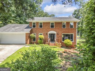 Charming brick home featuring well-maintained landscaping, a manicured lawn, and a welcoming front entry at 708 Delanie Way, Stone Mountain, GA 30083