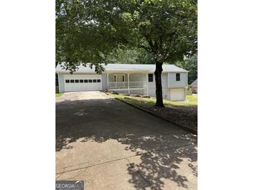 Charming home featuring an attached two car garage, basement garage, and inviting front porch at 276 Appalachee Church Rd, Auburn, GA 30011