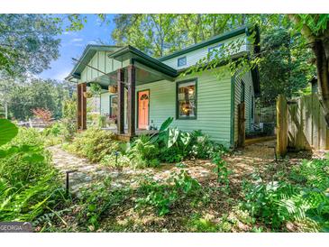 Charming home with colorful door, inviting front porch, and lush landscaping at 216 Leyden St, Decatur, GA 30030