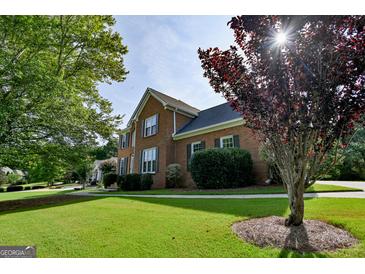 Traditional two-story brick home featuring a well-maintained lawn and mature landscaping at 165 Mcelwaney Way, Fayetteville, GA 30215