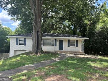 Charming brick home featuring a well-maintained lawn and beautiful mature trees for added curb appeal at 3129 Se Nursery Se Rd, Smyrna, GA 30082