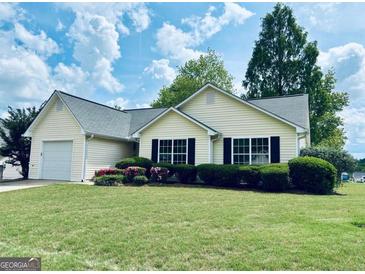 Charming single-story home featuring a well-manicured lawn and an attached garage at 486 Village Cir, Stockbridge, GA 30281