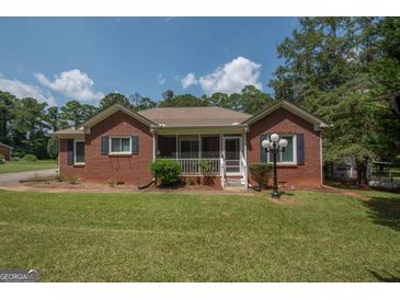 Charming brick home with a welcoming screened front porch and manicured lawn at 611 Bernhard Rd, Fayetteville, GA 30215