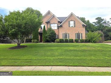 Charming two-story brick home with well-manicured lawn and mature landscaping at 910 Lilac Arbor Rd, Dacula, GA 30019