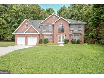 Charming two-story brick home with a well-manicured lawn and attached two car garage at 204 Eleanor Court, Stockbridge, GA 30281