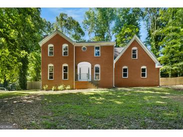 Charming brick two-story home with a symmetrical facade and a lush green lawn at 1783 Cheyenne Trl, Jonesboro, GA 30236