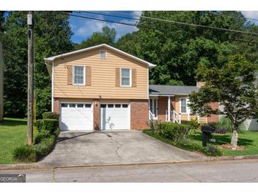 Charming two-story home featuring a two-car garage, brick accents, and a well-maintained front yard at 4402 Auburn Hills Drive, Stone Mountain, GA 30083