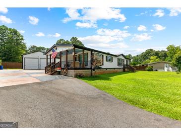 Charming single Gathering home with a well-manicured lawn, covered porch and detached garage at 80 David Rd, Hampton, GA 30228