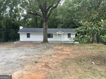 Charming one-story home with a large front yard and mature trees at 9075 Clark Rd, Fairburn, GA 30213