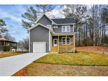 Charming two-story home with gray siding, a front porch, manicured lawn, and an attached garage at 192 Pecan Dr, Canton, GA 30114