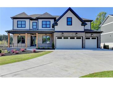 Charming two-story home with a three-car garage, covered porch, and professionally landscaped front yard at 2255 Buford Dam Rd, Buford, GA 30518