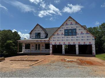 Under construction home featuring a two-car garage and inviting front porch area at 2257 Buford Dam Rd, Buford, GA 30518