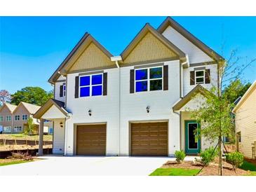 New construction two-story townhome with attached garage, complemented by professional landscaping and a vibrant blue sky at 3146-B Brownstone Se Ln, Atlanta, GA 30354