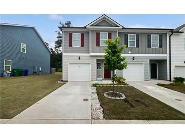 Charming townhome featuring a one-car garage and a well-maintained front yard at 3513 Lakeview Crk, Lithonia, GA 30038