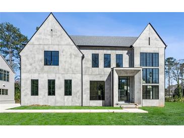 Stunning modern home showcasing large black-framed windows and a well-manicured lawn on a sunny day at 225 River Valley Lot 5 Ct, Atlanta, GA 30328