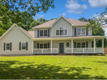 Charming two-story home featuring a covered front porch and beautifully landscaped front yard at 225 Woodfield Ct, Mcdonough, GA 30253