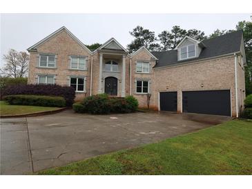 Lovely two-story brick home featuring a two-car garage, mature landscaping, and inviting curb appeal at 168 Harmony Grove Rd, Lilburn, GA 30047
