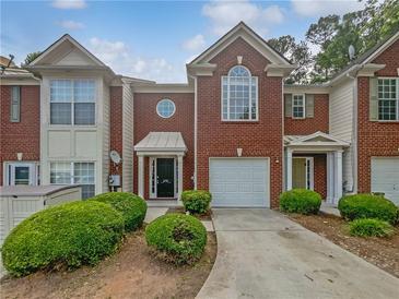Brick townhome with a one-car garage and well-maintained landscaping at 2708 Parkway Trl, Lithonia, GA 30058