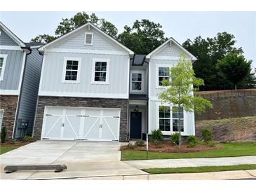 Charming two-story home with stone accents, white garage door and a well-manicured lawn at 360 Lakeside Ct, Canton, GA 30114