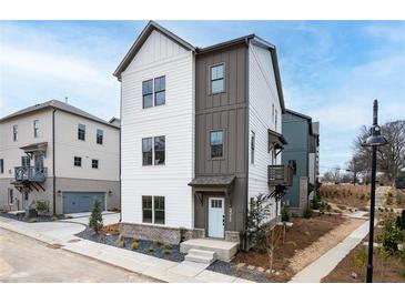 Attractive two-story home with a combination of white and gray board and batten, featuring a welcoming front porch at 3317 Stillwood Ln, Hapeville, GA 30354
