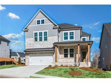 Charming two-story home featuring a brick facade, inviting front porch, and a two-car garage at 3025 Sunset Pass, Canton, GA 30114