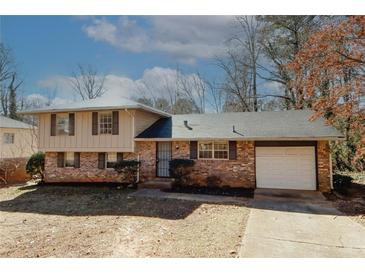 Brick ranch house with attached garage and mature trees at 4374 Cedar Ridge Trl, Stone Mountain, GA 30083