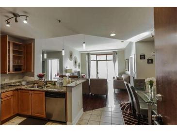 Open floor plan showcasing a kitchen with granite counters and a living area with ample natural light at 171 Auburn Ave # 329, Atlanta, GA 30303