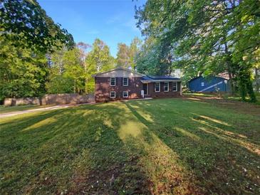 Charming brick home with a well-manicured lawn and mature trees at 3371 Vandiver Dr, Marietta, GA 30066