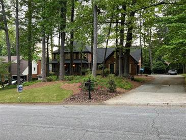 Charming brick home with mature trees, landscaped yard, and long driveway at 5741 Wolf Laurel, Lilburn, GA 30047