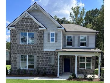 Beautiful two-story home featuring a brick facade, gray siding, covered porch, and manicured front lawn at 558 Abbott Se Ct, Atlanta, GA 30354