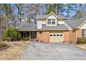 Charming home featuring a brick facade, attached garage, and meticulously landscaped front yard at 6 Dover Trl, Peachtree City, GA 30269